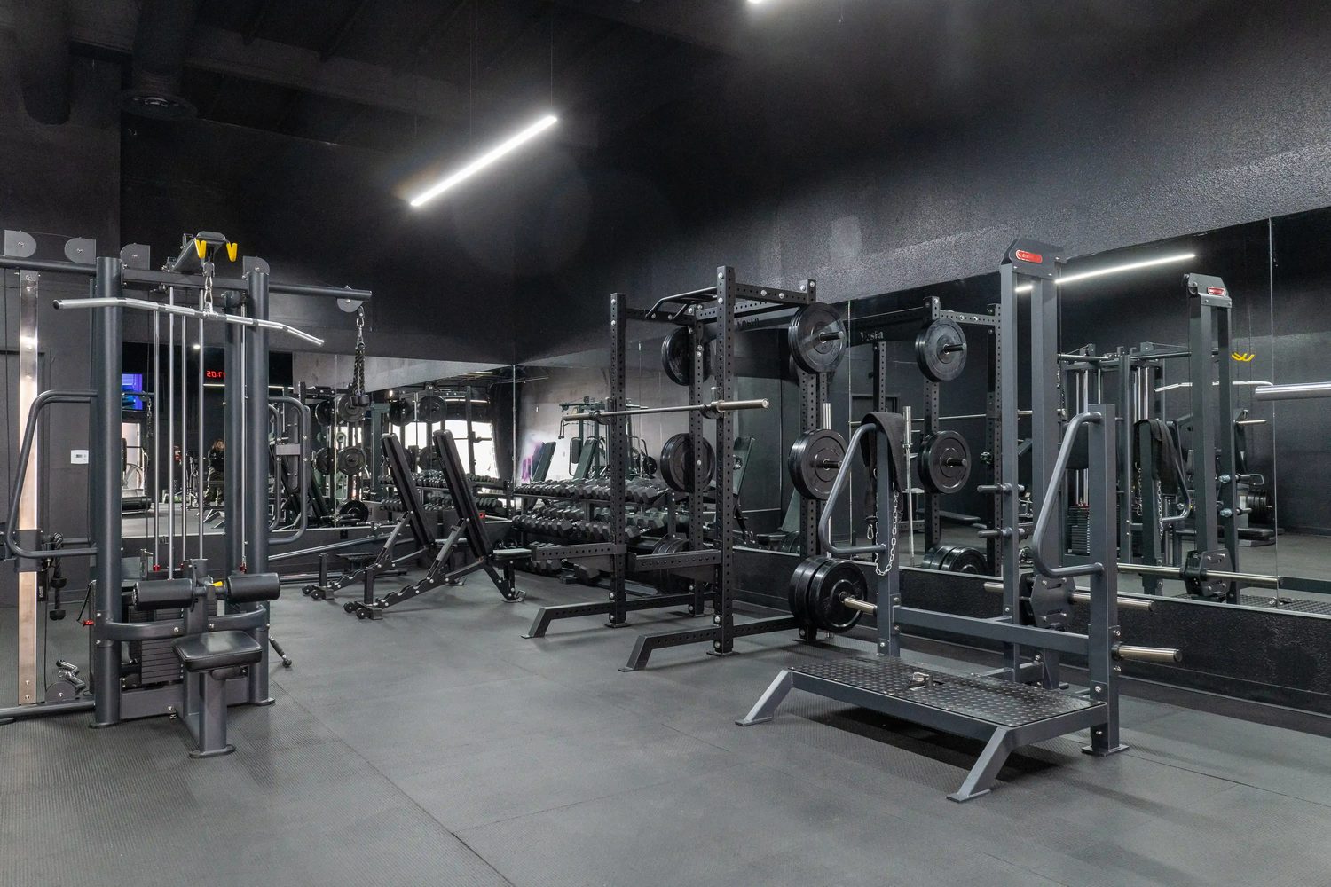 BodyKore commercial gym equipment — A boutique studio floor. Racks, a functional trainer and dumbbells in 