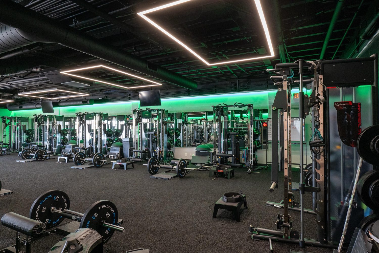 BodyKore commercial gym equipment — A full commercial training floor — Universal Trainers in a row, powder