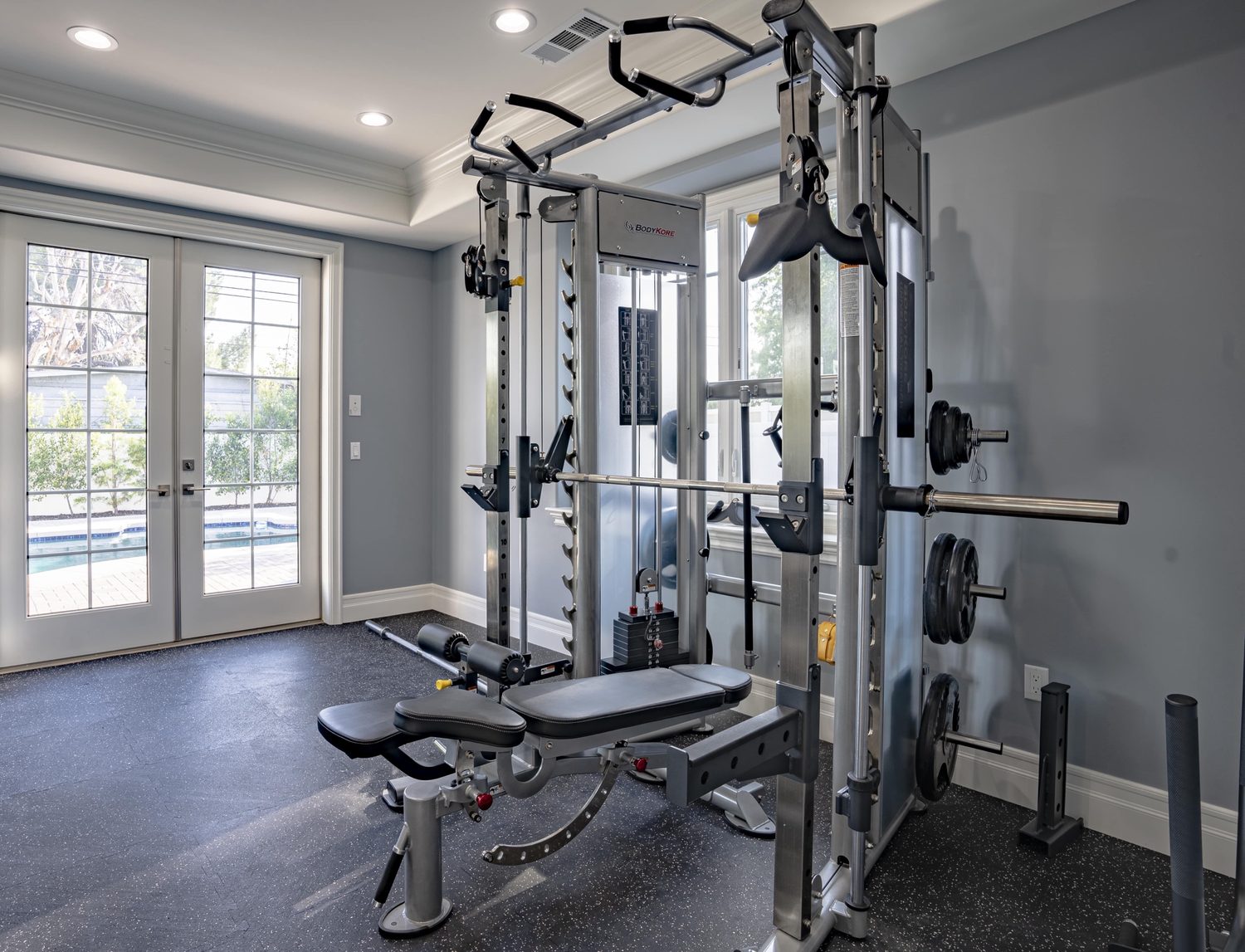 Home gym with a Smith machine and bench in a converted room