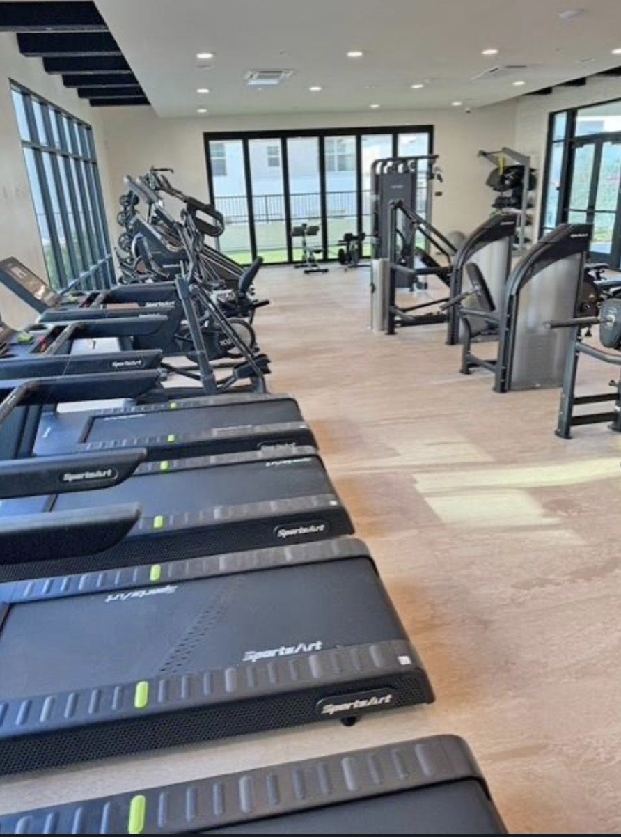 Treadmills along a window wall in an apartment amenity room