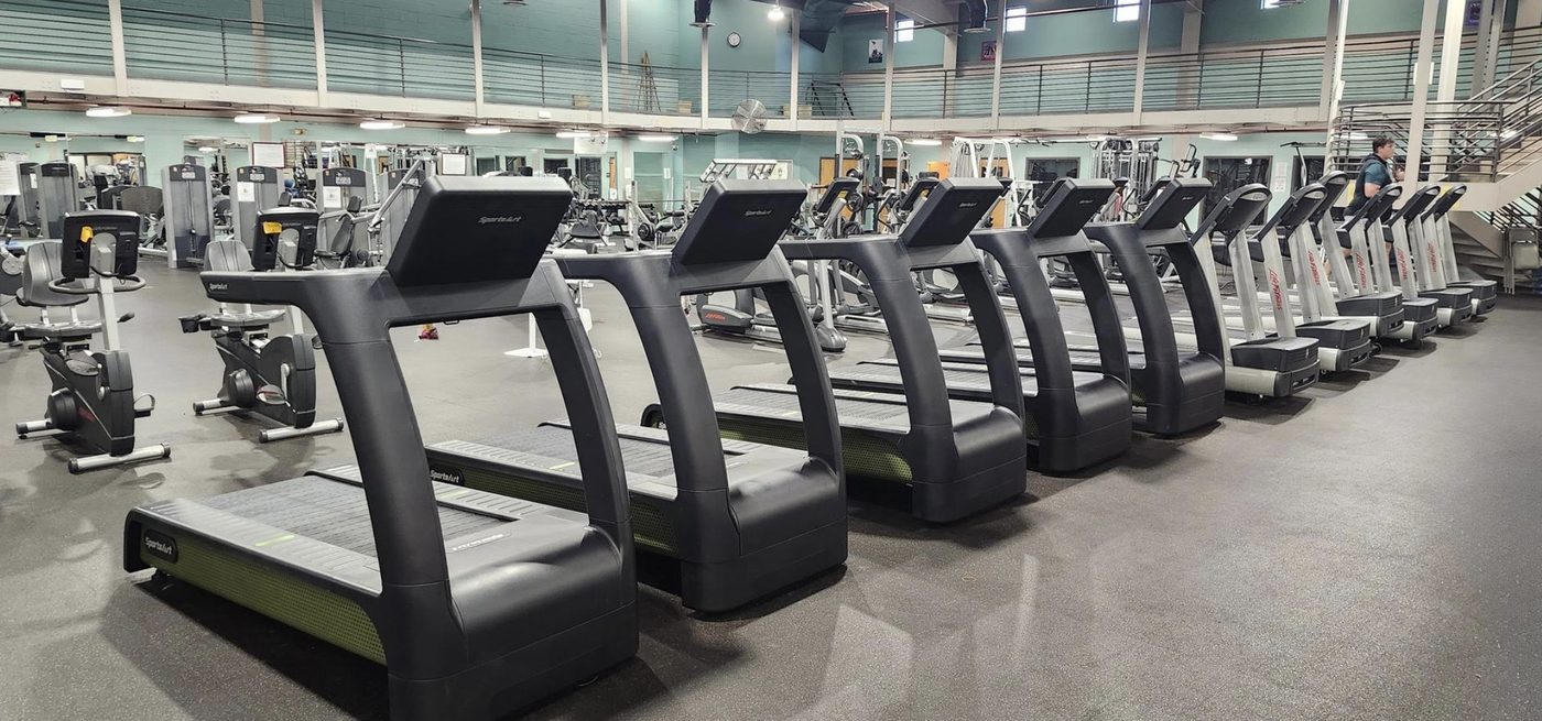 Row of commercial treadmills in a health club