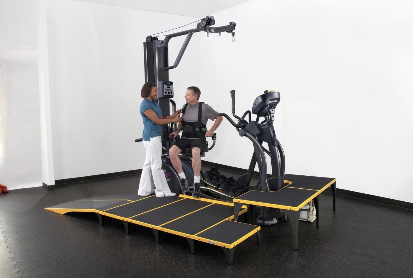 SportsArt ICARE — therapist fitting the support harness before a session