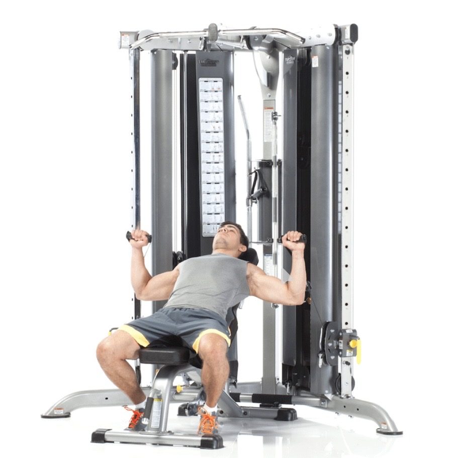 TuffStuff commercial strength equipment — Functional trainer paired with an adjustable bench, set up for incline