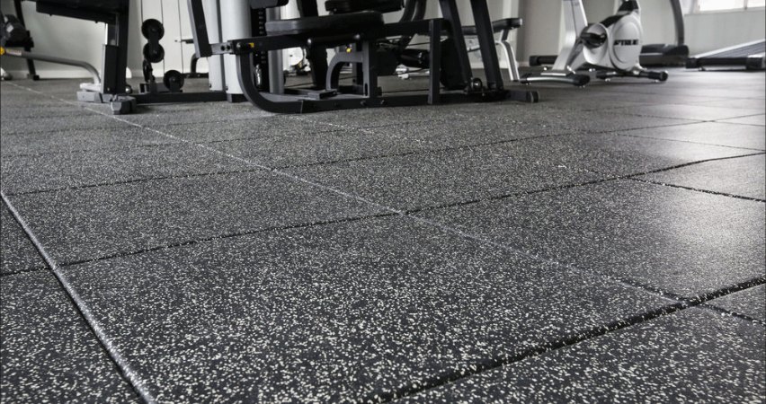 Interlocking rubber gym tiles with fleck pattern across a commercial strength floor